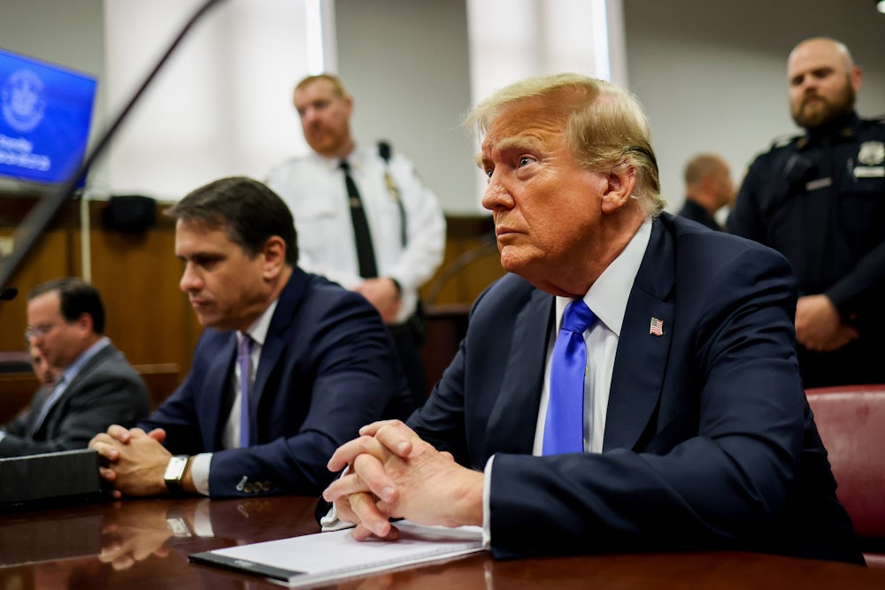 Former President Donald Trump sits at the defendant's table inside the courthouse.